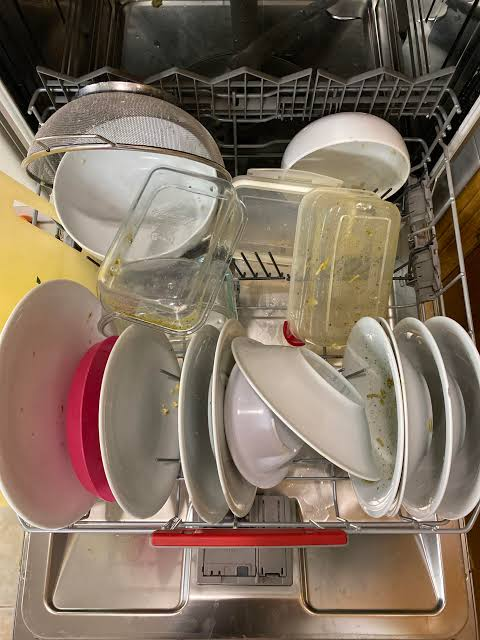 ضعف الغسيل قبل إصلاح الرشاش والمضخة أوانٍ متسخة داخل غسالة الصحون قبل الصيانة - dirty dishes inside a dishwasher before service
